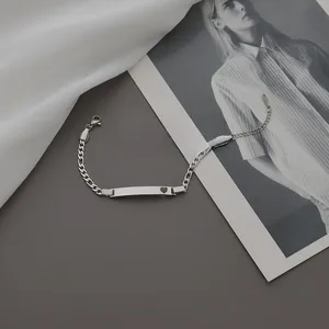 Vue détaillée d'un bracelet gourmette en acier inoxydable argenté avec breloque cœur ajouré