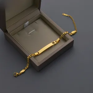 Détail d'un bracelet à plaque d'identité dorée avec cœur évidé et son coffret cadeau