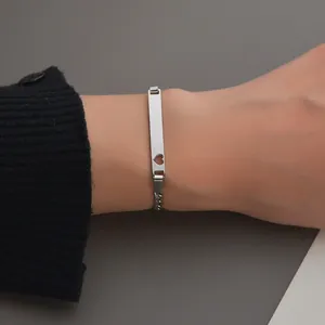 Détail du bracelet en acier inoxydable avec une découpe de cœur sur la plaque d'identification