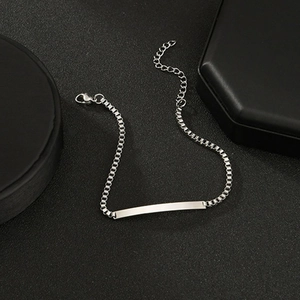 Detail of silver stainless steel box chain bracelet with flat rectangular engraving bar