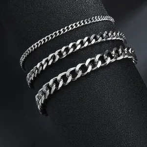 Close-up of three different widths of silver Cuban link chains on a black display