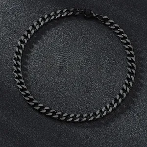 Close-up of matte black stainless steel Cuban link chain in circular layout display