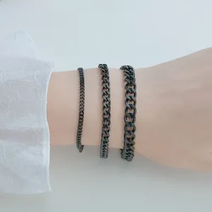 Detailed comparison of three black stainless steel Cuban link bracelets on a wrist