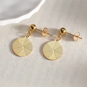Detail of 14K gold-plated drop earrings with radial geometric texture and sphere studs
