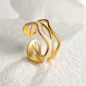 Elegant 18k gold plated stainless steel wave ring with white enamel detail on stone texture