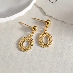 Macro detail of 14K gold plated oval earrings featuring intricate woven textures and relief