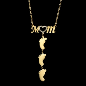 Close-up of golden MOM necklace with heart crystal and three baby footprints detail