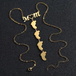 Vintage gold MOM necklace with diamond heart and four baby footprint pendants in stainless steel