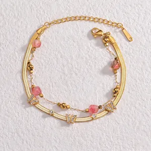 Double-layer gold bracelet with pink beads and butterfly pendants decorated with zircons