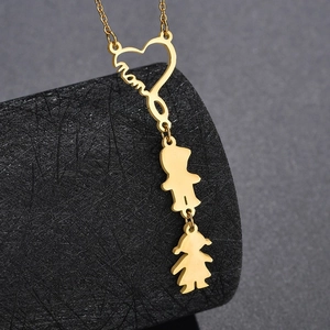 Primer plano de colgante de corazón dorado con grabado mom y figuras pequeñas