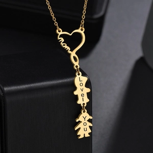 Collar de corazón Mom de acero de titanio dorado con siluetas de niños sobre joyero negro