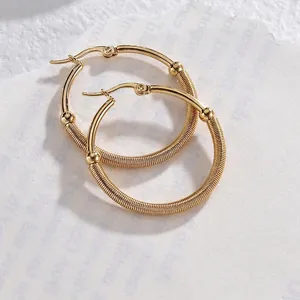 Eleganti orecchini a cerchio dorati con filo a spirale e piccoli grani metallici