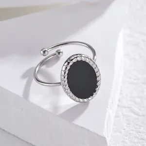 Close-up of silver adjustable ring with oval black stone and twisted rope edge detail