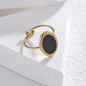 Detailed macro shot of a golden oval shell ring featuring an elegant twisted rope border