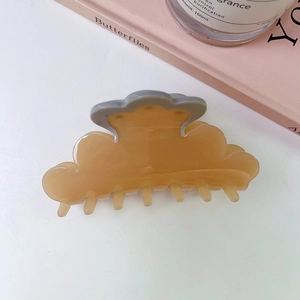 Elegant translucent amber cloud hair claw clip with grey curved accent on white surface
