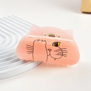 Gros plan détaillé d'une pince à cheveux chat en acrylique rose avec ressort doré