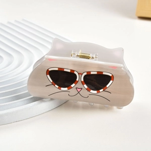 Détail d'une pince à cheveux chat de dessin animé avec lunettes et ressort métallique doré