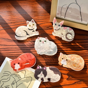 Set of cute acetate cat hair claws in various patterns on a rustic wooden table