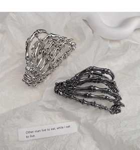 Detailed view of silver and black metal skeleton hand hair claws for Halloween styles