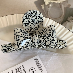 Détail de la pince à cheveux en acétate dalmatien avec logo doré France handmade