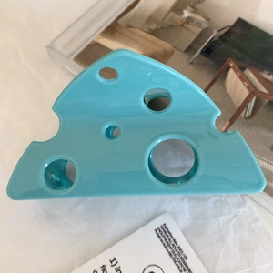 Detail of creative blue Swiss cheese hair claw clip with triangular hollow pattern