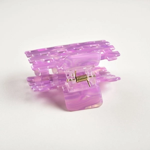 Macro detail of purple marble acetate hair claw showing metal spring and texture