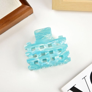 Detail of blue and white marble pattern acetate claw clip with square cutout design