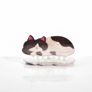 Detail of cute black and white cat hair claw clip made of glossy acetate material