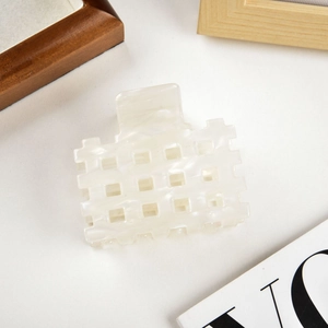 Detail view of the square hollow hair claw clip with white marble pattern and acetate texture