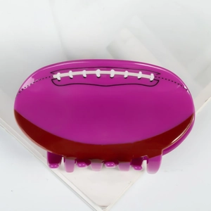 Dettaglio della clip per capelli in acrilico viola a forma di pallone da football