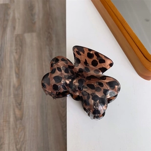 Vue détaillée de la pince à cheveux noeud motif léopard en acrylique avec ressort