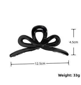 Detailed view of a black bow hair claw clip with dimensions 12.5cm and 33g weight