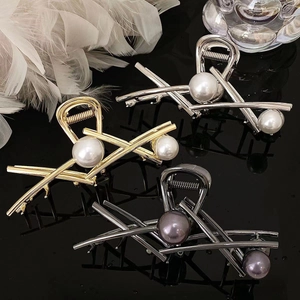 Detail of high-quality metal hair claws with elegant faux pearls in gold and silver finish
