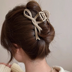 Matte khaki bow hair claw clip shown in a sophisticated updo for women's hairstyling