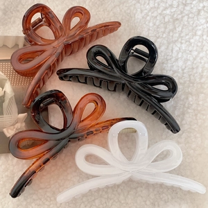 Elegant large butterfly hair claw clips in four colors on soft white background