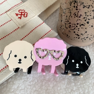 Primer plano de lindas pinzas para el cabello con forma de perro en varios colores