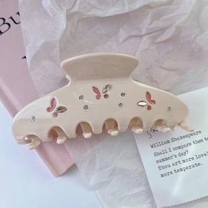 Detail of cream shark hair clip with pink enamel butterflies and sparkling rhinestones