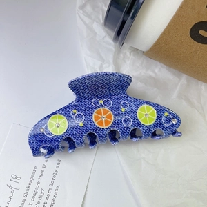Détail de la pince à cheveux bleue en acétate avec motifs de citron et strass brillants