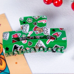 Détail de la pince à cheveux de Noël verte avec motifs rennes et cannes de bonbon