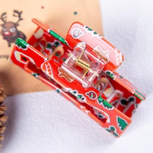 Détail de la pince à cheveux rouge de Noël aux motifs de pain d'épice et de sucre