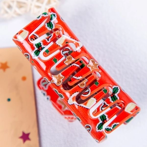 Détail de la pince à cheveux rouge brillante avec des motifs festifs de Noël