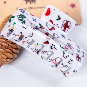 Gros plan d'une pince à cheveux de Noël blanche avec motifs de bonbons colorés