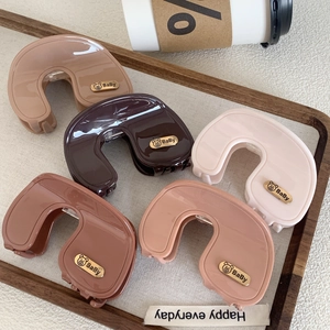 Set of five elegant brown and pink acetate shark hair clips on a wooden tray with a teddy bear charm