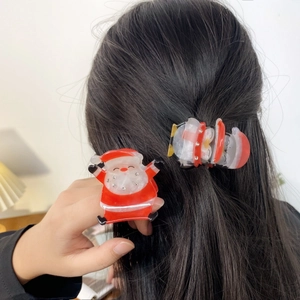 Pinces à cheveux Père Noël étincelantes avec strass montrées sur cheveux foncés