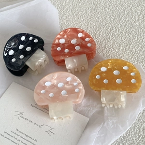Détail de pinces à cheveux en forme de champignon avec texture marbrée en acétate