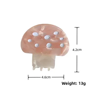 Détail d'une pince à cheveux champignon en acétate marbré orange avec points blancs