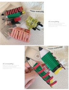 Dettaglio di fermagli per capelli in acrilico a forma di matita e clip con ciliegie
