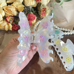 Elegant butterfly hair claw with pearlescent white finish and delicate floral patterns