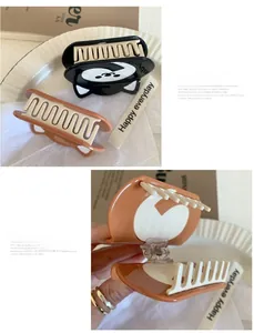 Detail of cute cat shaped hair claws in black and amber colors with sturdy metal springs