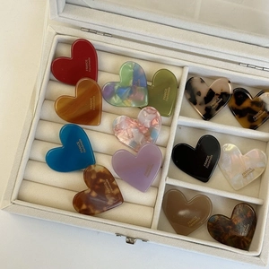 Assorted heart-shaped hair clips in leopard and solid colors set in a velvet box